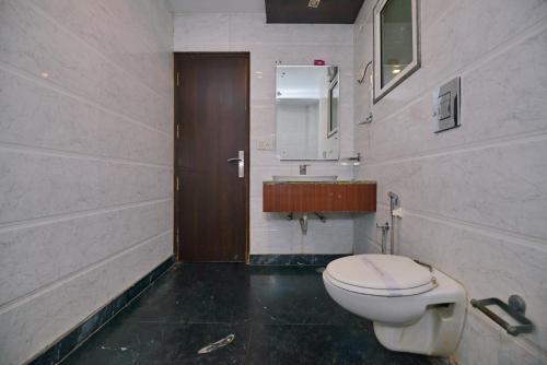 a bathroom with a toilet and a sink at Hotel Krishna Deluxe-By RCG Hotels in New Delhi