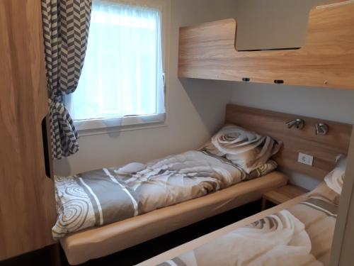 2 camas en una habitación con ventana en Saksida Holiday Park en Zalošče