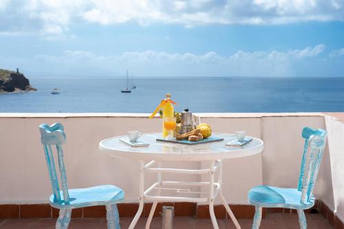 a table and two chairs on a balcony with the ocean at Casa Athina in Procida