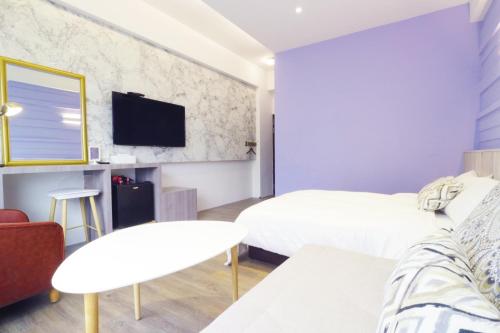a hotel room with two beds and a tv at 36 Lighthouse in Hualien City