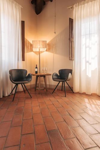 a room with two chairs and a table with a lamp at Villa Aia Vecchia in Bibbona