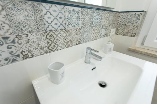a bathroom with a white sink and a mirror at Villa Aurora Mondello Addaura in Mondello