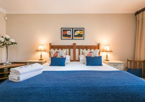 a bedroom with a large bed with blue sheets and pillows at Caledon 23 Country House in George