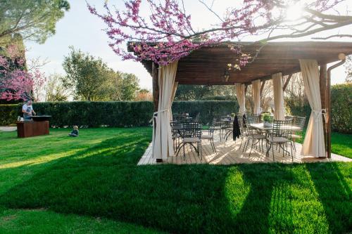 a gazebo with tables and chairs in a park at Villa Aia Vecchia in Bibbona