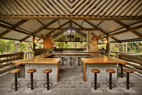 a room with wooden tables and stools in a pavilion at Capivari Ecoresort in Campina Grande do Sul