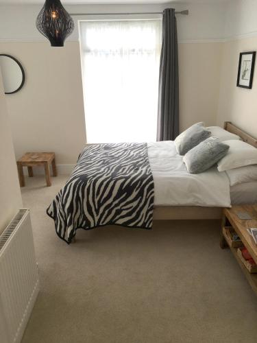 a zebra print bed in a bedroom with a window at 1 Ashford Road Guesthouse in Redhill