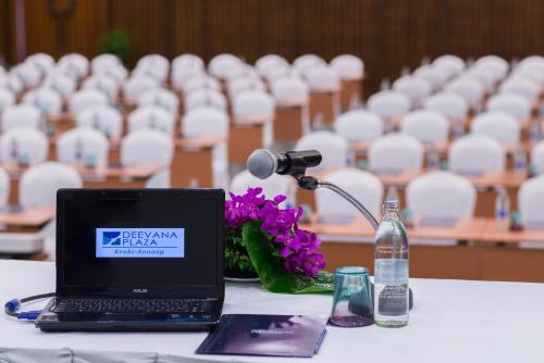 a laptop computer sitting on a table with a microphone at Deevana Plaza Krabi Aonang - SHA Extra Plus in Ao Nang Beach