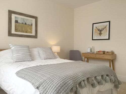 a bedroom with a white bed and a desk at 1 Ashford Road Guesthouse in Redhill
