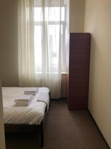 a bedroom with a bed with a window and a dresser at El Mundo Apartments in Lviv