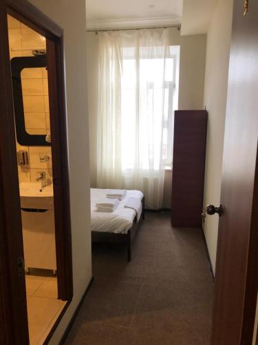 a bedroom with a bed and a sink and a window at El Mundo Apartments in Lviv
