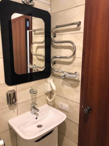 a bathroom with a sink and a mirror at El Mundo Apartments in Lviv