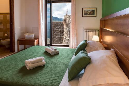a bedroom with a bed with two towels on it at Murat Guesthouse in Pizzo