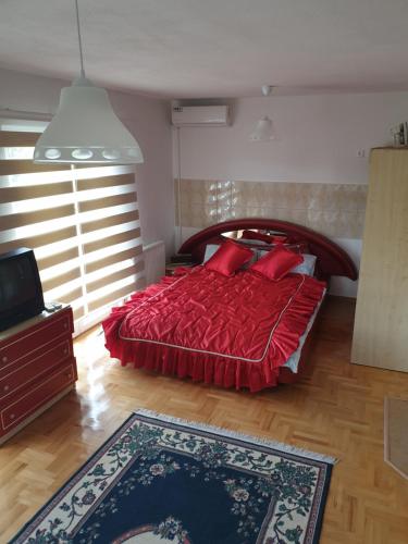 بيت عطلات دجوغيك في إيليجا: غرفة نوم بسرير ذو شراشف حمراء ومخدات حمراء