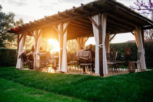 a group of people sitting under a pavilion at Villa Aia Vecchia in Bibbona