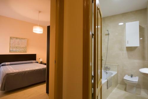 a bedroom with a bed and a bathroom with a sink at CASA DEL CIRCULO MERCANTIL in Villanueva del Arzobispo