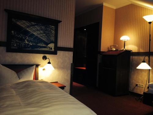 a hotel room with a bed and two lamps at Hotel BB Bahnhof Bertsdorf in Olbersdorf