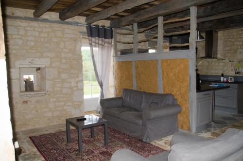 a living room with a couch and a table at Les Gîtes du Villajou in Lachapelle-Auzac
