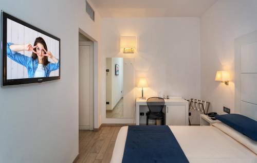a hotel room with two beds and a television at Hotel Central Park in Marina di Pietrasanta