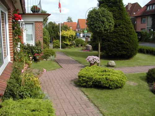 a garden with a brick walkway next to a house at Haus Waldenfels in Sankt Peter-Ording