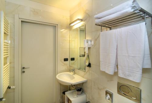 a bathroom with a toilet, sink and shower stall at Hotel Central Park in Marina di Pietrasanta