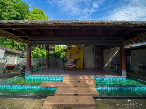 um pavilhão com piscina no quintal de uma casa em Baan Ma Feung GuestHouse em Kanchanaburi