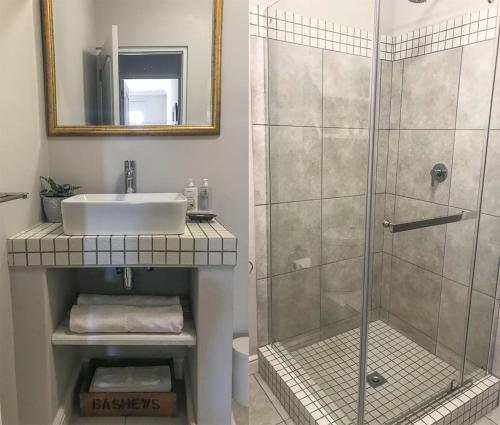 ein Bad mit einem Waschbecken und einer Dusche in der Unterkunft Lavender Suite in Kapstadt