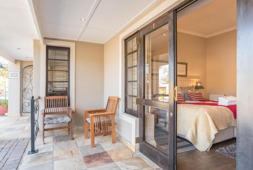 a bedroom with a bed and a balcony at Caledon 23 Country House in George