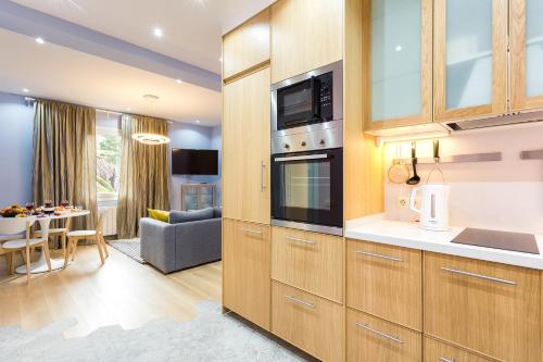 a kitchen with wooden cabinets and a living room at Three bedrooms apartment in Barcelona