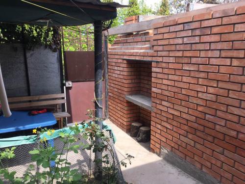 a brick wall with a bench in a garden at Dom v Arkadii in Odesa