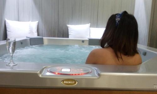 a woman sitting in a bathtub with a glass of wine at Hotel Sila in Camigliatello Silano
