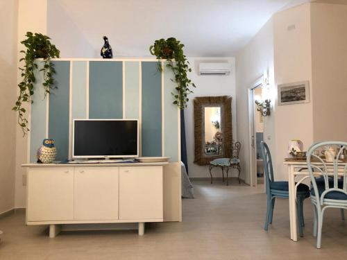 soggiorno con TV e armadio di Appartamenti Milù a La Maddalena