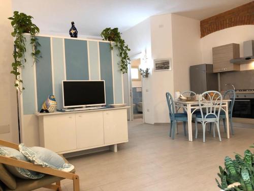 a living room with a television and a table with chairs at Appartamenti Milù - Milù Holidays in La Maddalena