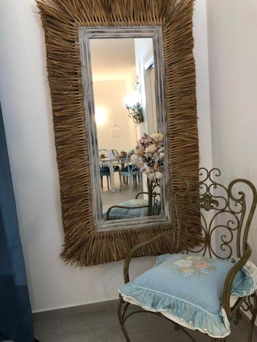 a mirror on a wall with a chair and a table at Appartamenti Milù - Milù Holidays in La Maddalena