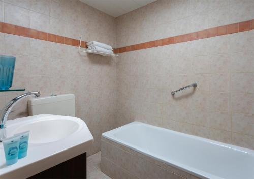 a bathroom with a sink and a tub and a toilet at The Little House In Bakah in Jerusalem
