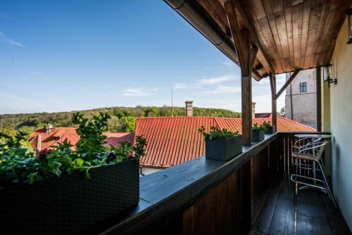 a balcony with pots of plants on a roof at Penzion U Hrádku in Kutná Hora