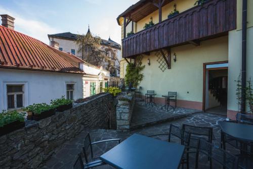 an outdoor patio with tables and chairs next to a building at Penzion U Hrádku in Kutná Hora