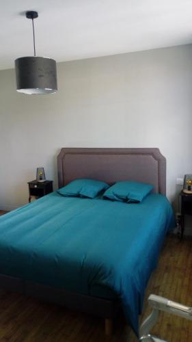 a bedroom with a blue bed with blue pillows at Les bains de mer in Saint-Quay-Portrieux