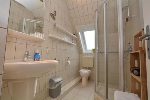 a bathroom with a sink and a toilet and a shower at An de Warft Appartement 10 Schatz am Deich in Büsum