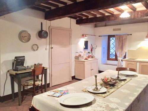 a kitchen with a table with plates on it at Camera e Appartamento Toscana - B&B Palazzo Robicci in Castiglion Fiorentino