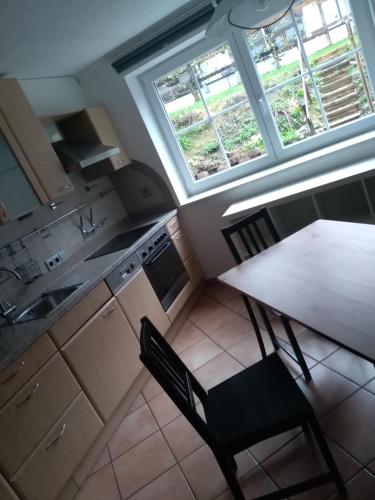 a kitchen with a table and a table and two windows at Ferienwohnung Zechner in Waidring