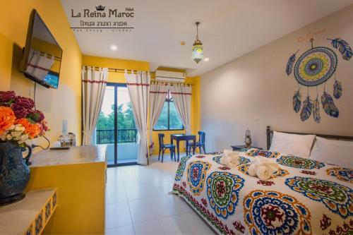 a hotel room with a bed and a table and chairs at La Reina Maroc Hotel ปากช่อง เขาใหญ่ in Pak Chong
