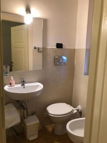 a bathroom with a sink and a toilet and a mirror at B&B Casale Coreallo Spotorno in Spotorno