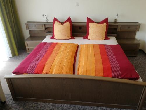 a bed with colorful blankets and pillows on it at Gästehaus Bausch in Mehring