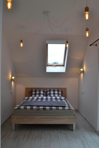 a bedroom with a bed in a room with a window at LENIÓWKA in Ponikiew