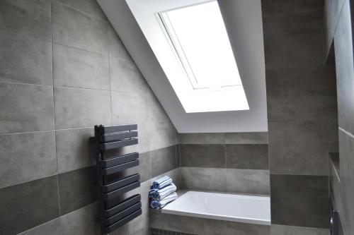 a bathroom with a bath tub with a skylight at LENIÓWKA in Ponikiew