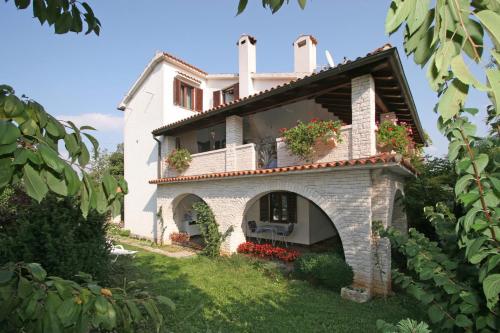 an external view of a house with flowers at Apartments Ruby in Funtana