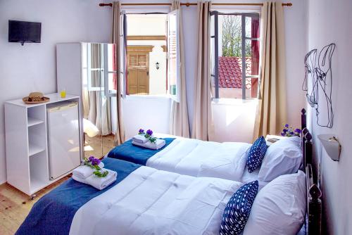 a bedroom with two beds with blue and white pillows at Talos in Chania