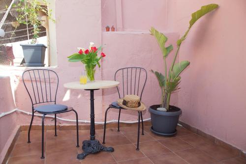 two chairs and a table and a table and a plant at Talos in Chania