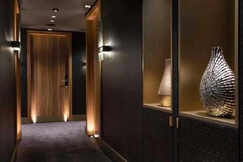a hallway with two vases on shelves and a hallway sidx sidx sidx at Hotel D Geneva in Geneva