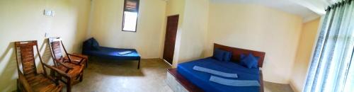 a bedroom with a blue bed and a chair at Lake Bliss in Dambulla